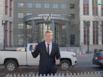 Benny Johnson stands in front of the Transportation Department Building and hands out free bottles of water from the tap of East Palestine, Ohio.