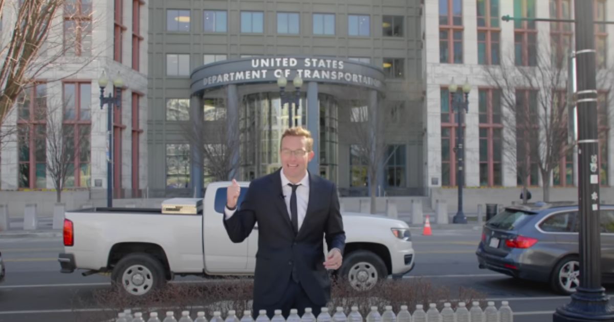 Benny Johnson stands in front of the Transportation Department Building and hands out free bottles of water from the tap of East Palestine, Ohio.