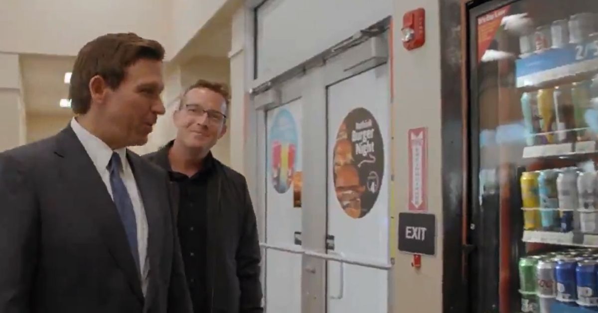 Florida Gov. Ron DeSantis looks over the beer selection at a convenience store with Benny Johnson.