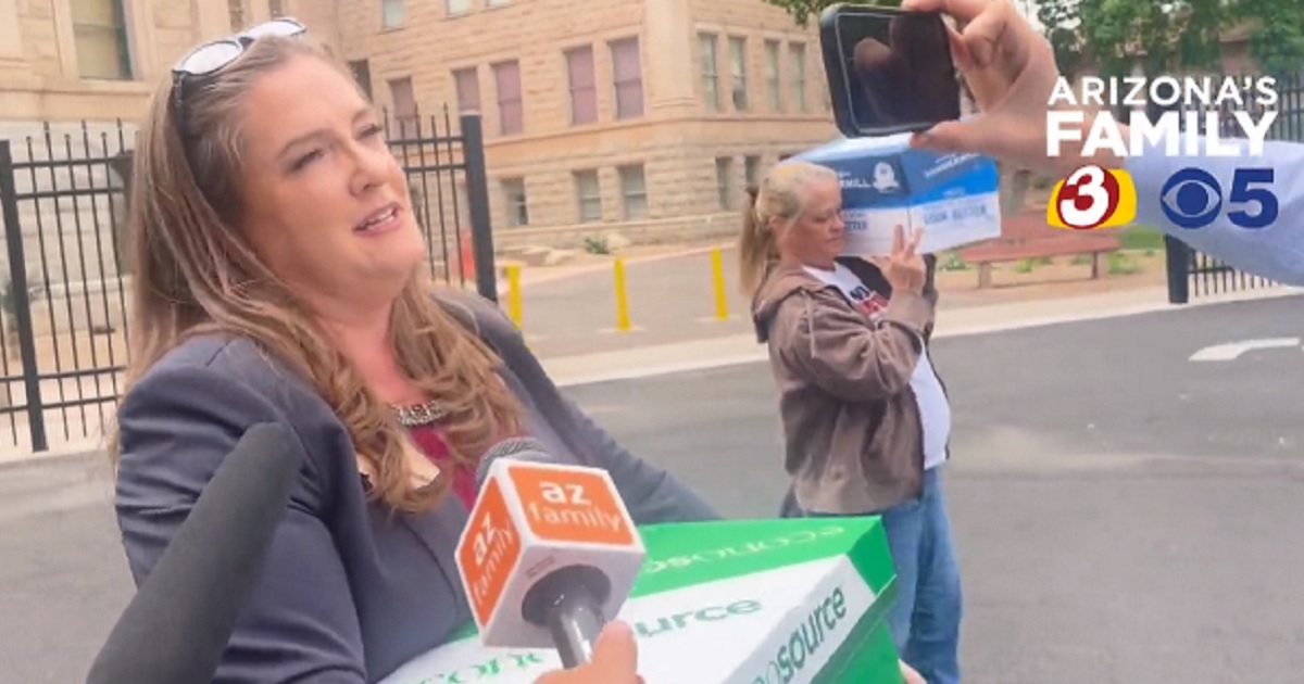 Arizona state Rep. Liz Harris, a Republican, carries belongings in a box from her office to a car after the state House voted to expel her on Wednesday.