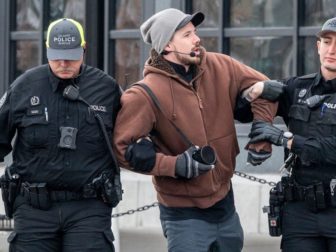 Pastor Derick Reimer, middle, is seen with police in Canada.