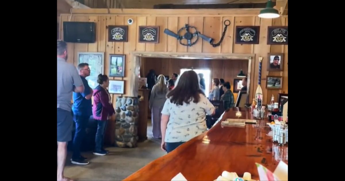 Patrons of the Rainbow Oaks Country Market in the Southern California town of Fallbrook stand for the national anthem.