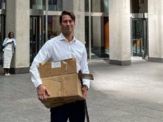 Former Fox News producer Alexander McCaskill carries a box with his personal belongings after his departure from the network.