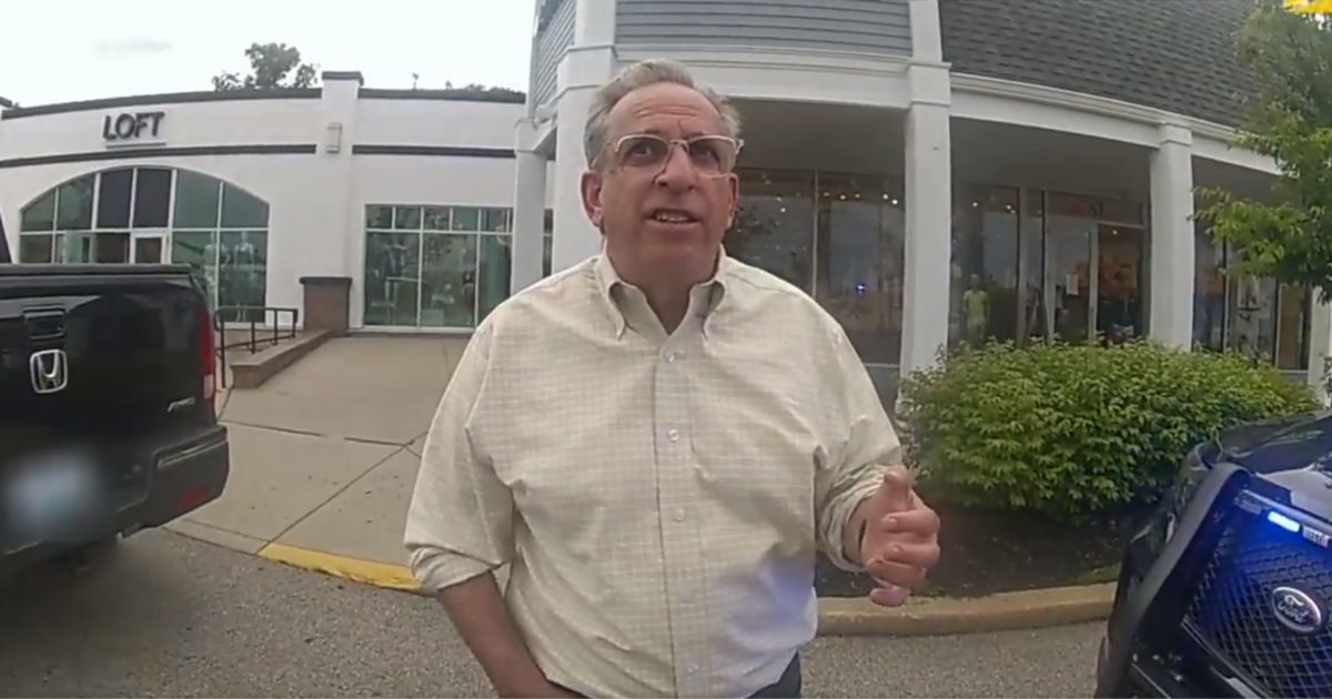 Rhode Island Senator Joshua Miller talks to police about keying the car of a Trump supporter in Cranston, Rhode Island, on Thursday.