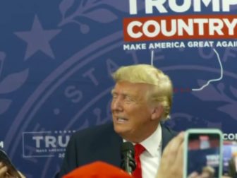 Former President Donald Trump reads the license plate handed to him by a fan in New Hampshire.