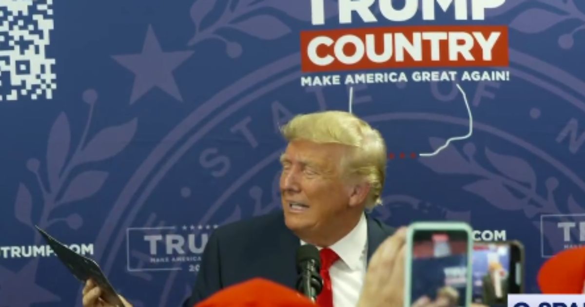 Former President Donald Trump reads the license plate handed to him by a fan in New Hampshire.