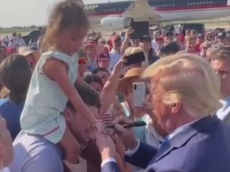 Former President Donald Trump signs a young girl's hand in Louisiana.