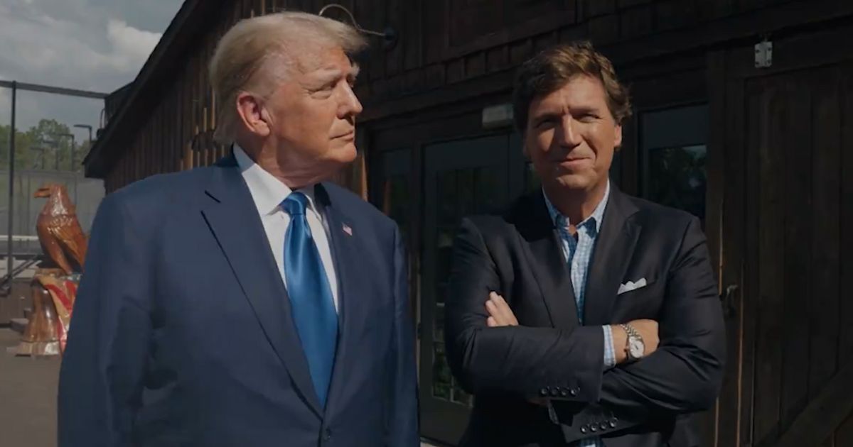 Former President Donald Trump stands with Tucker Carlson before their interview on X.