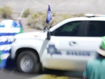 A tribal police vehicle crashes through protesters' barricade in Nevada.