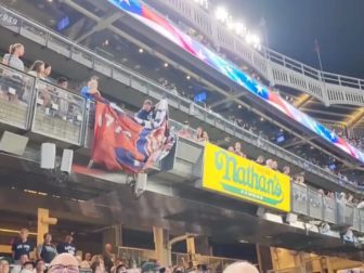 Supporters of former President Donald Trump display a Trump flag at Yankee Stadium on Wednesday.