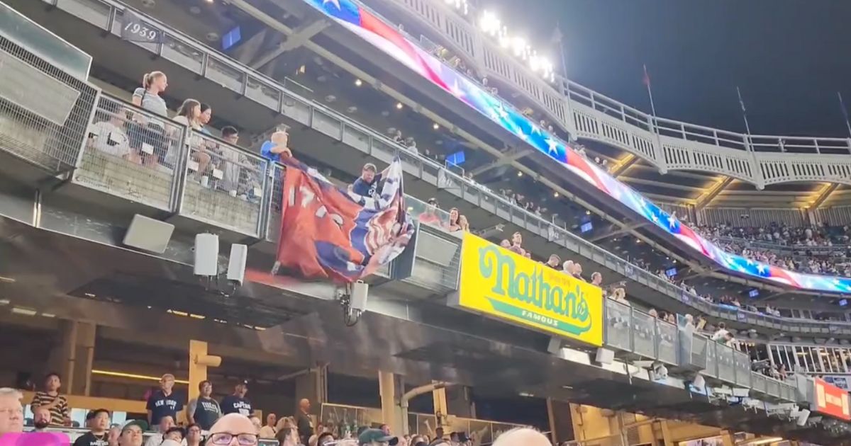 Supporters of former President Donald Trump display a Trump flag at Yankee Stadium on Wednesday.