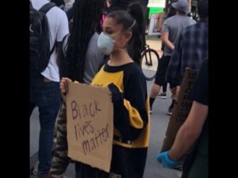 Singer Ariana Grande holds a BLM sign.