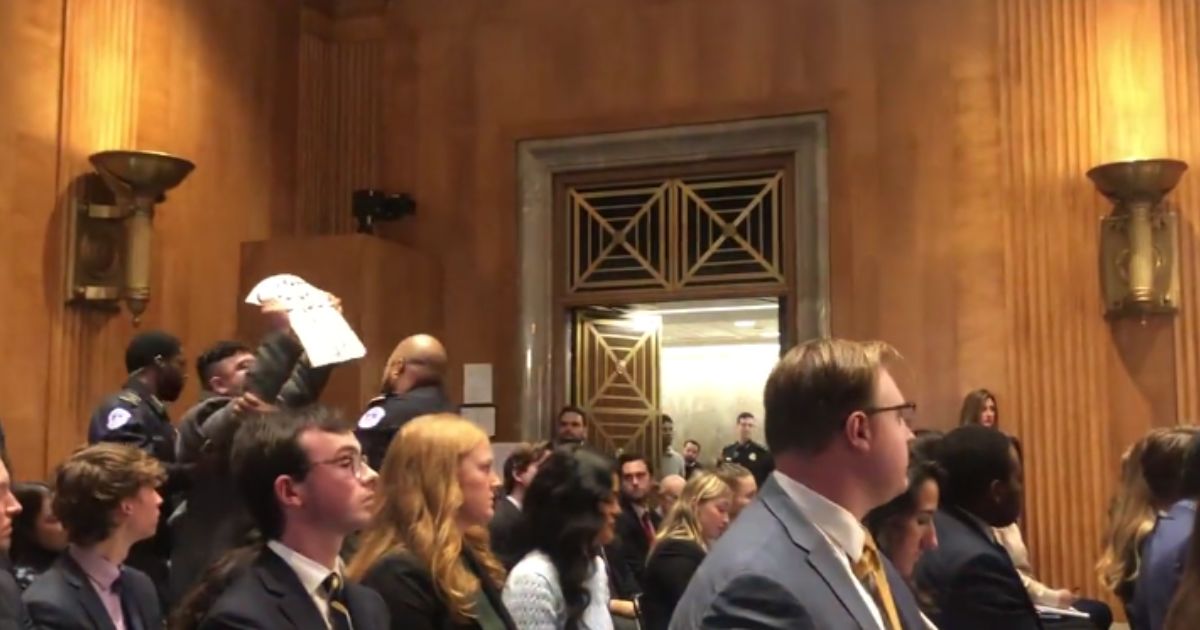 A protester is removed during the Senate Foreign Relations Committee nomination hearing.