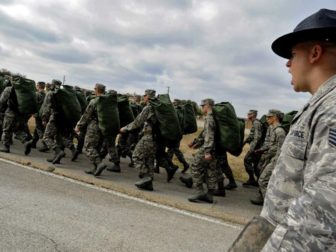 Staff Sgt. Robert George, a military training instructor at Lackland Air Force Base, Texas, marches his recruits following the issuance of uniforms and gear during basic training.