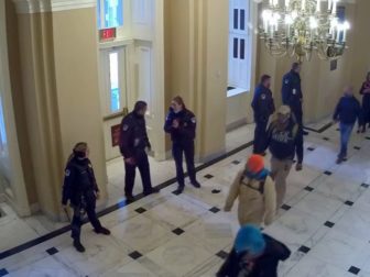 Video released Friday from Jan. 6, 2021, shows protesters strolling calmly down the hallway with some Capitol Police officers appear to casually look on.