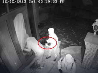 A still from a surveillance video shows a gang breaking into a home -- with one of the men holding a jammer.