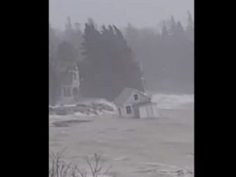 A cabin bobs in the water after being swept off the ground by flood waters in Maine.