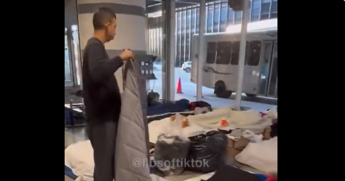 A migrant adjusts bedding at Chicago's O'Hare Airport.