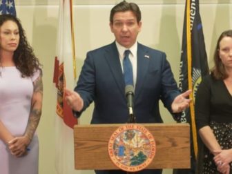 Florida Gov. Ron DeSantis is flanked by two of the late Jeffery Epstein's victims, Haley Robson, left, and Jena-Lisa Jones, after signing a bill Thursday into law that officially authorizes the release of documents from a grand jury investigation in Palm Beach County regarding Epstein's sexual assault of underage girls.
