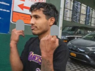 One of the five men charged with attacking two NYPD officers in Times Square "saluted" onlookers upon leaving court.