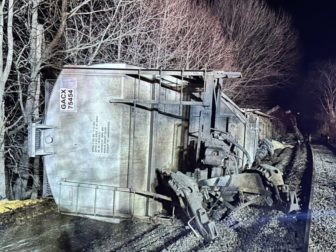 Two rail cars ended up in the Hoosic River, with two more teetering above it, in what was described as a "non-hazardous" spill resulting from a derailment in New York.