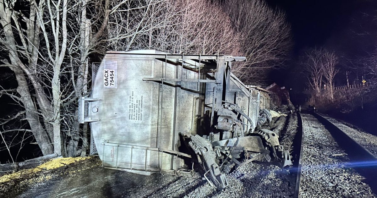 Two rail cars ended up in the Hoosic River, with two more teetering above it, in what was described as a "non-hazardous" spill resulting from a derailment in New York.