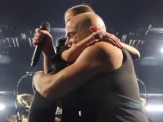 David Draiman, the frontman and vocalist of the band Disturbed, hugs a 9-year-old fan during a concert after she handed him a bracelet with the words, "Am Israeli Chai."