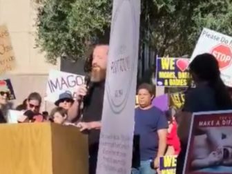 Pastor Jeff Durbin, center, of Apologia Church in Mesa, Arizona, was not deterred by an abortion protester, center, who shouted slogans as he prayed outside the state capitol building.