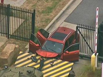 An SUV is stuck in the gate of the FBI's Atlanta office on Monday.