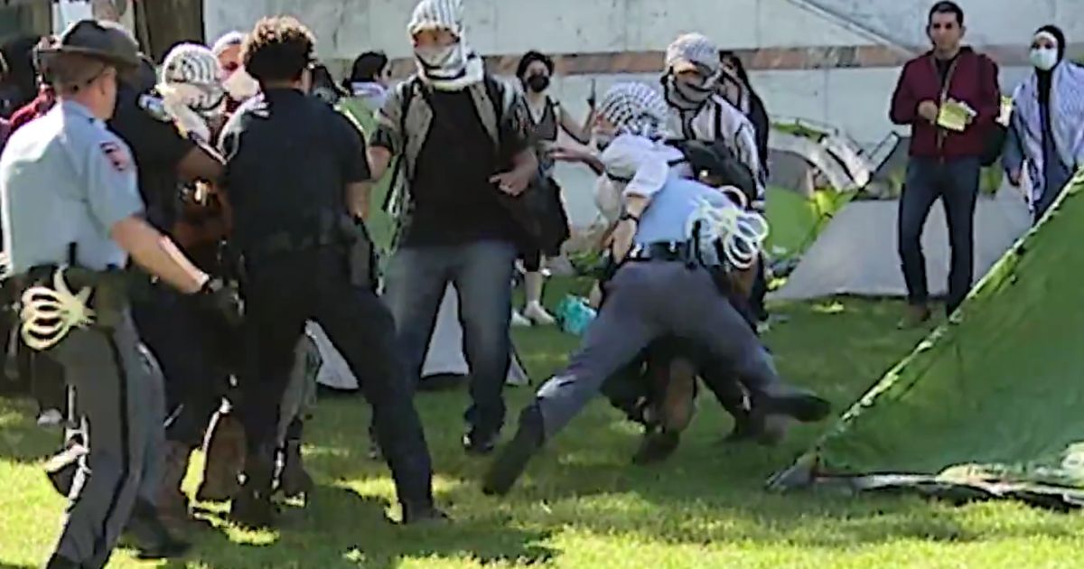 A Georgia State Patrol trooper tackles a pro-Palestine protester on the Emory University campus.