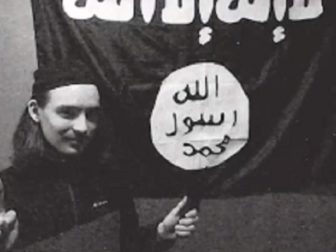 Alexander Scott Mercurio, 18, is pictured before a flag of the Islamic State group in a still from a CNN news cast about his arrest.