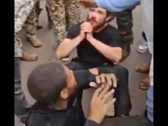 Two man sit on the ground surrounded by Congolese soldiers after a coup attempt Sunday in Kinshasa, the capital of the Democratic Republic of Congo.