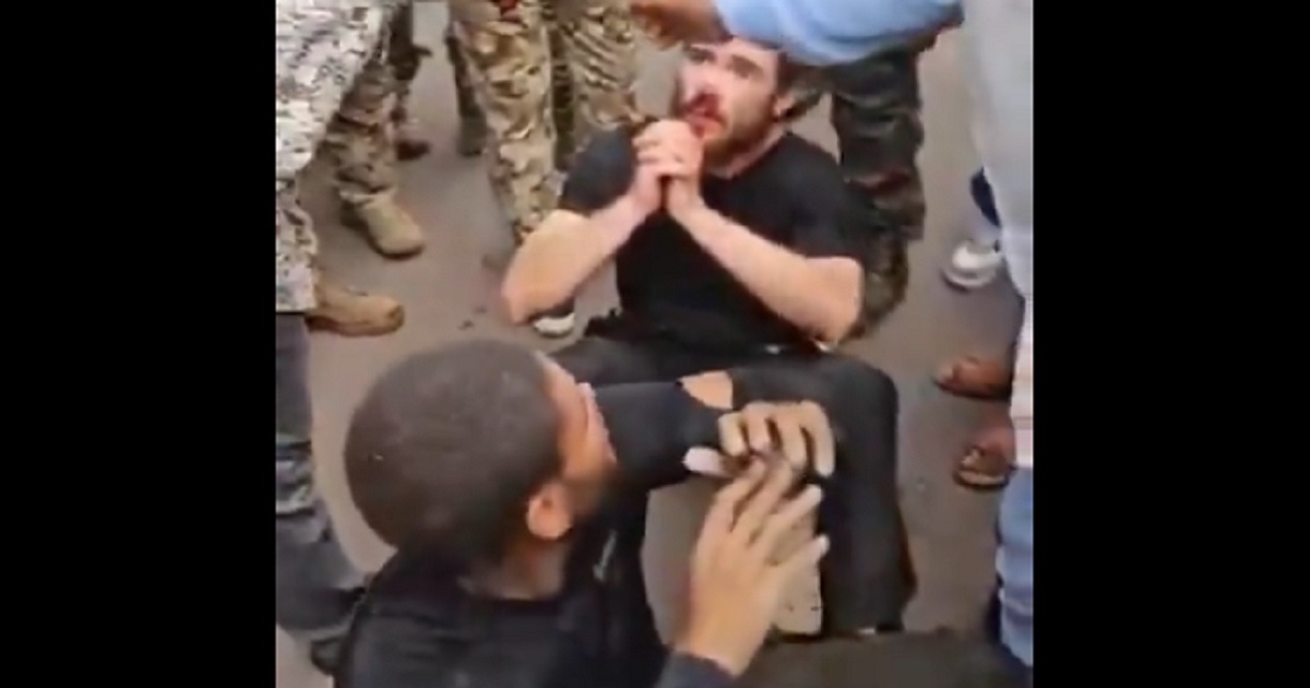 Two man sit on the ground surrounded by Congolese soldiers after a coup attempt Sunday in Kinshasa, the capital of the Democratic Republic of Congo.